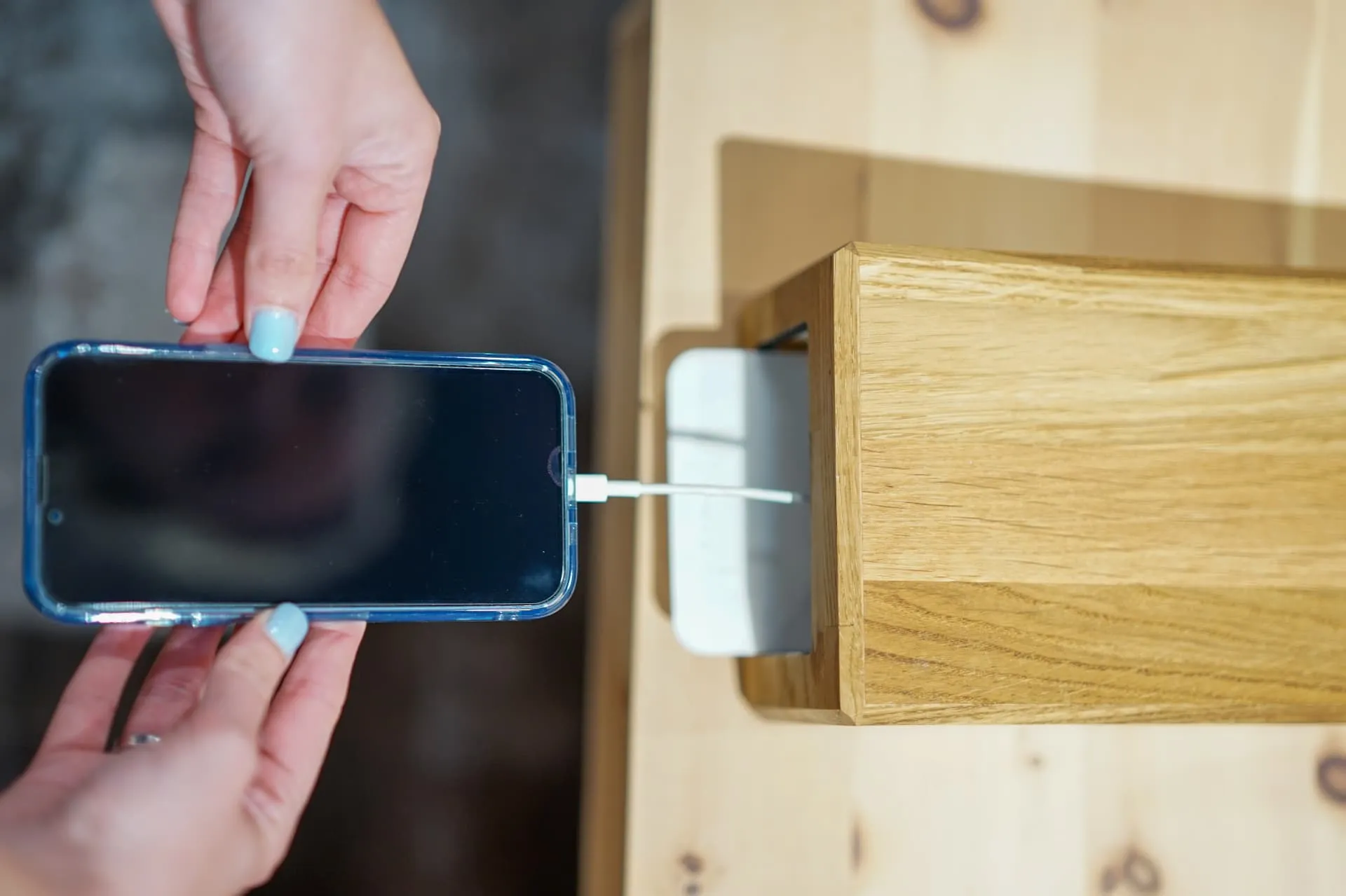 Ein Smartphone mit Ladekabel wird in die Flameey Box eingelegt